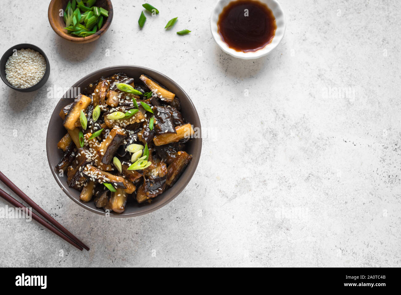 Stir fried aubergine in bowl. Corean, chinese or asian vegan meal - eggplant stir fry with soy sauce sweet glaze, top view, copy space. Stock Photo