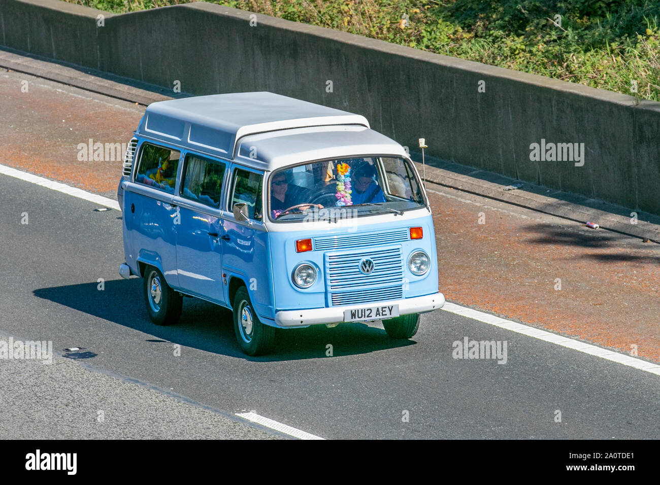 2012 blue white VW Volkswagen motorhome; UK Vehicular traffic, transport, recreational cars, high top roof, roofs, pop top, caddy, Transporter, camper vans, kombi, combi, campervan vans, motorhome, conversion, Vee Dub, conversions, microbus, bus, campers, drop roof, Volkswagen motorhomes south-bound on the 3 lane M6 motorway highway. Stock Photo