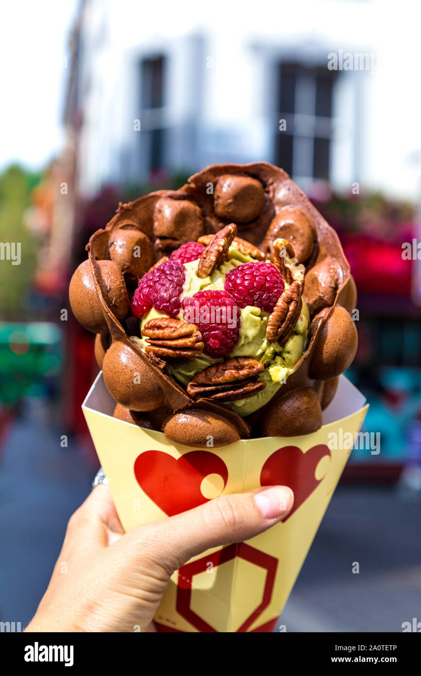 Pistachio sorbet in a cocoa waffle garnished with pecans and raspberries from Bubblewrap ice cream shop, Chinatown, London, UK Stock Photo