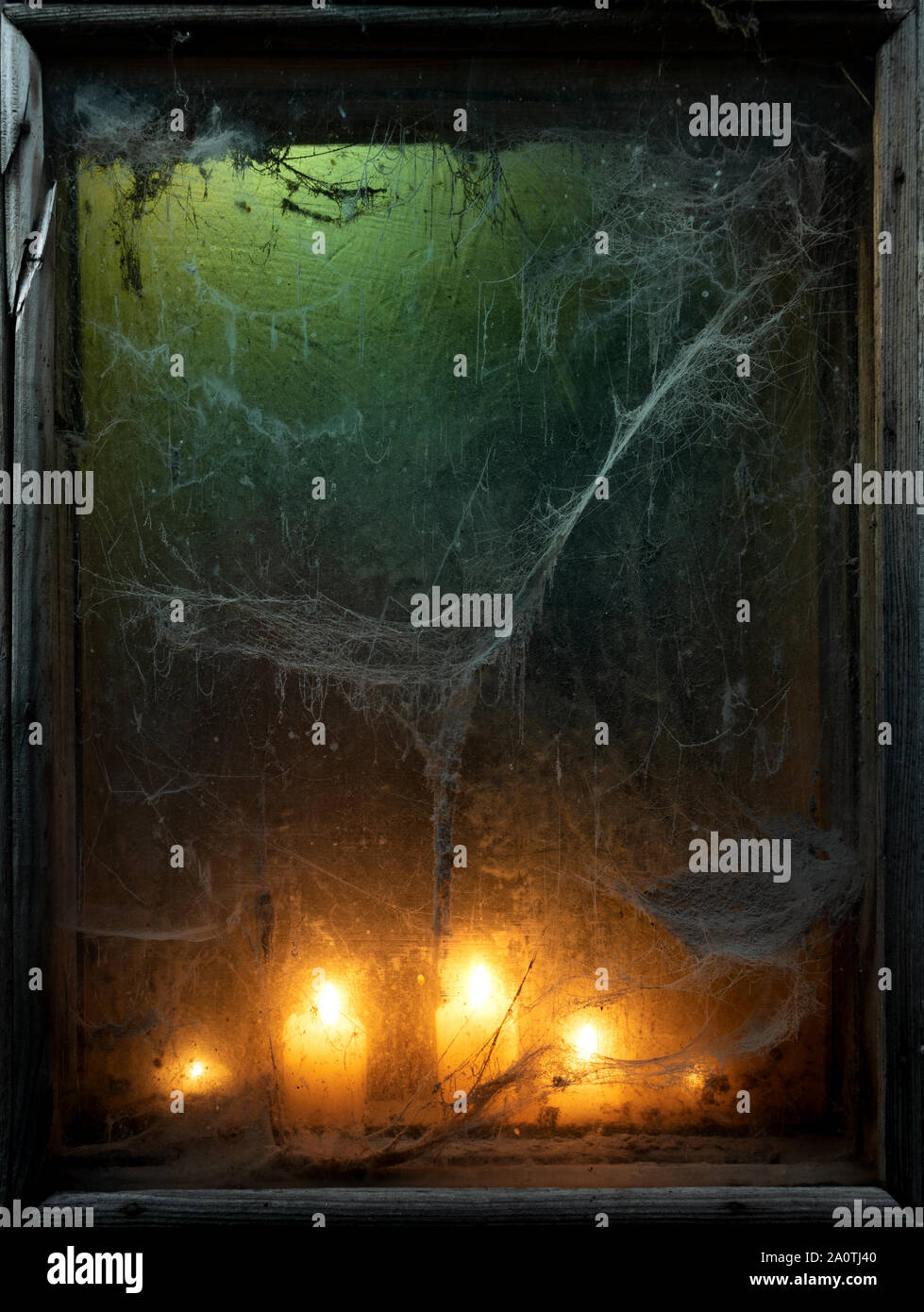 Halloween background with creepy old spider web in a scary dark window Stock Photo