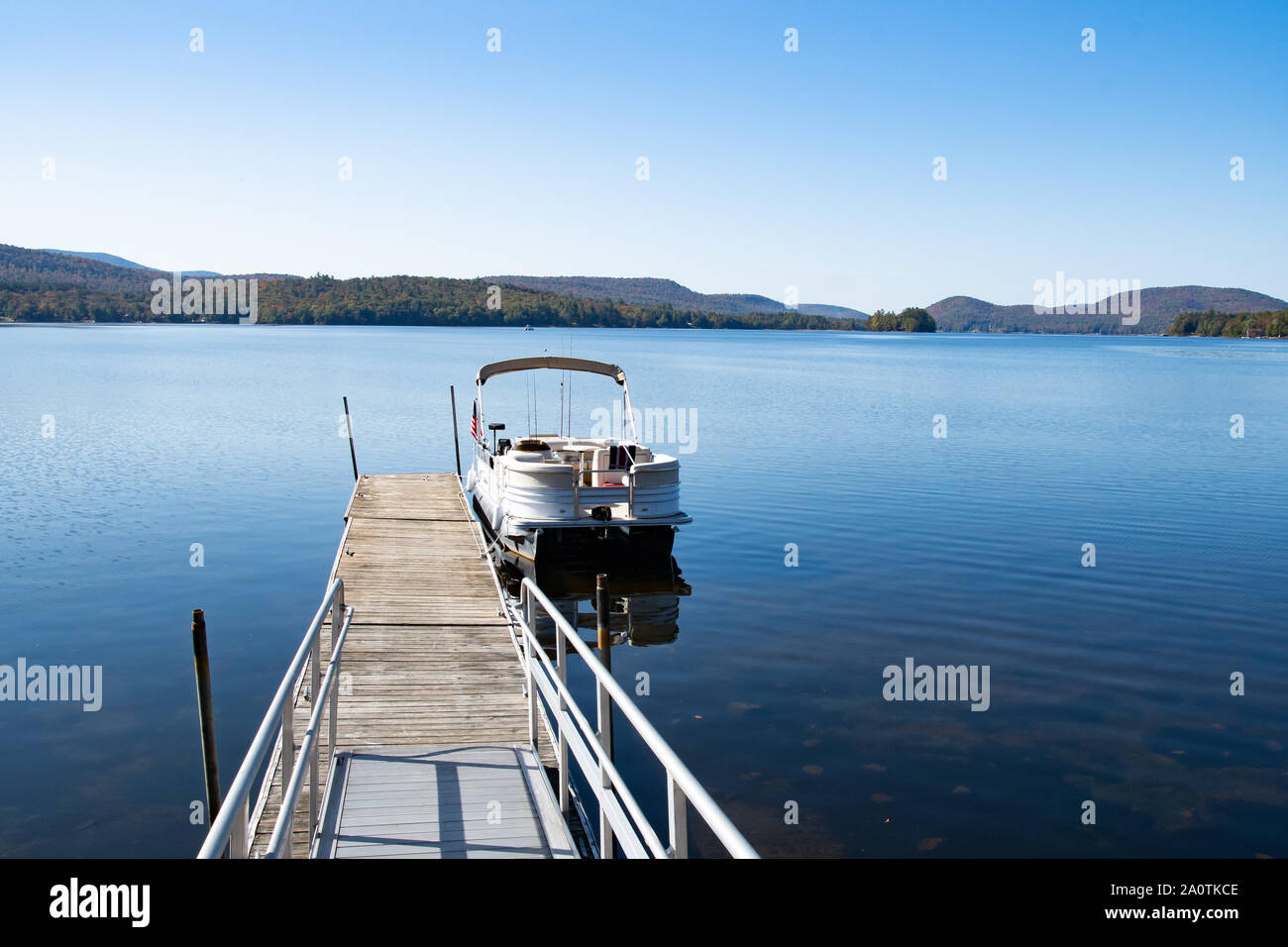 A pontoon boat tied up to the village dock at Osborne Point on Lake