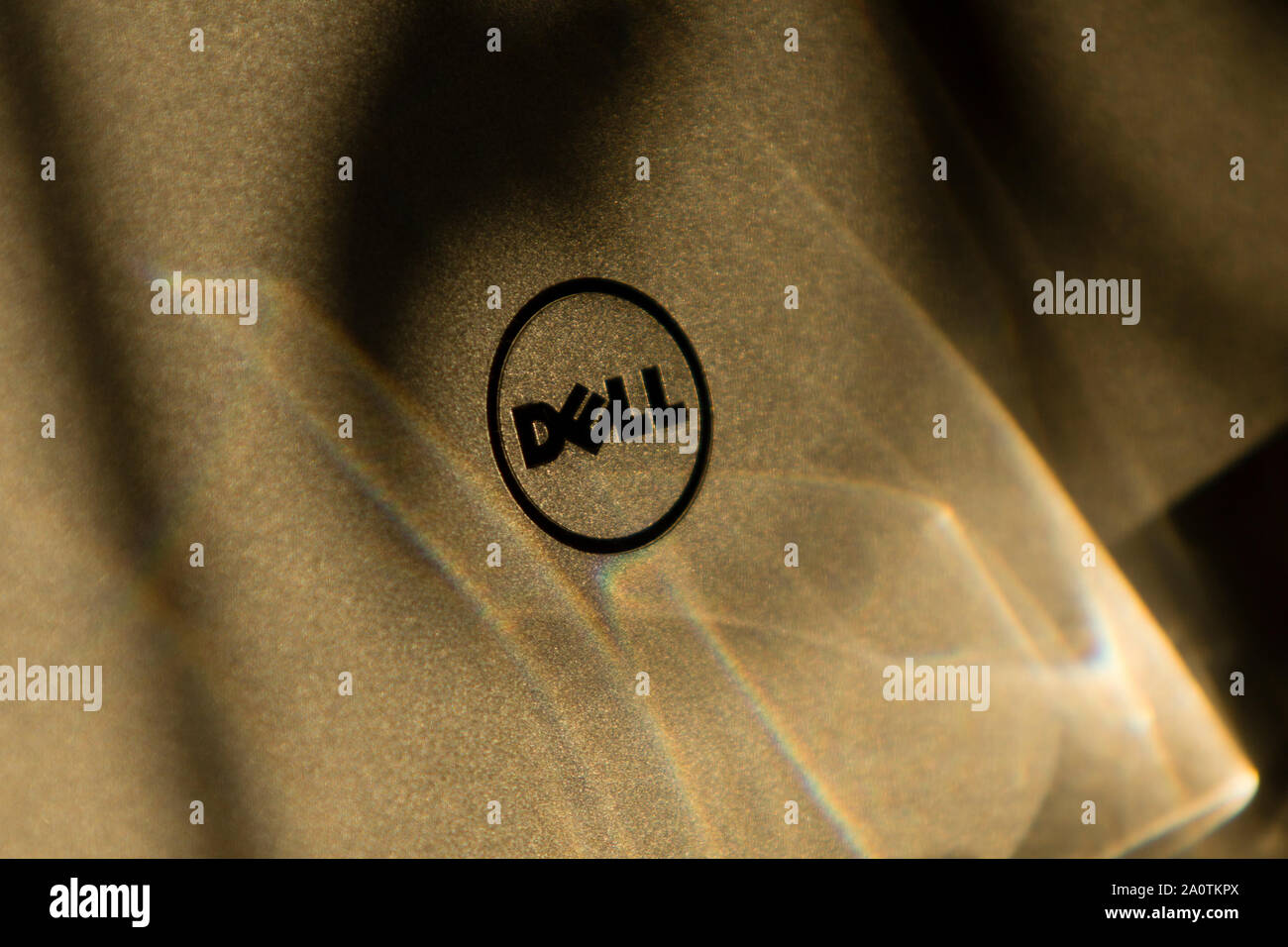 Top view of a Dell XPS ultrabook's aluminum lid with logo washed with lights of a prism. Stock Photo