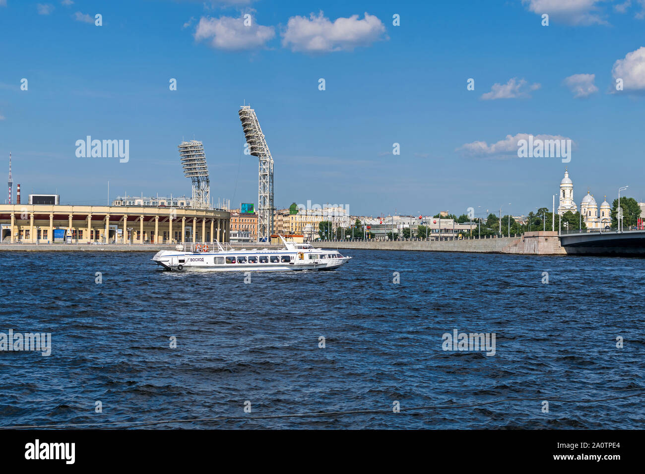 Saint Petersburg, Russia -  July 27, 2019: Petrovsky or Lenin Stadium, Petrogradsky island with St. Vladimir's Cathedral and Tuchkov Bridge across Lit Stock Photo