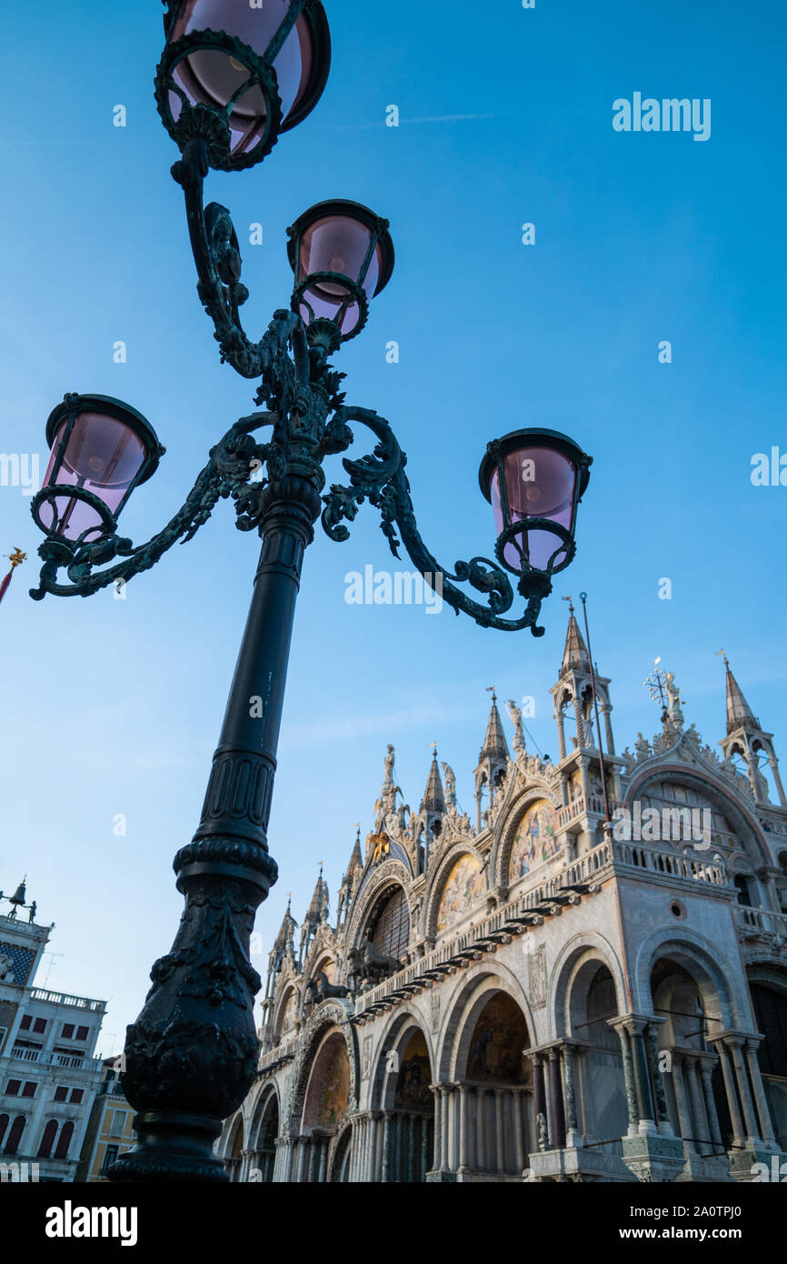 Ornate lamp posts at dusk with St Marks Basilica, St Mark's square, Venice, Italy Stock Photo