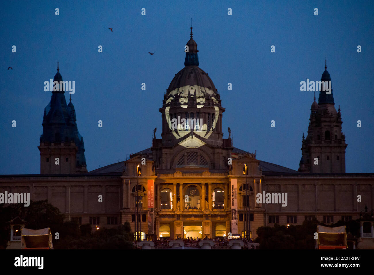 Batman Bat signal appears projected on the facade of the  Palau Nacional de Montjuic in Barcelona on occasion of the character’s 80th anniversary. Stock Photo