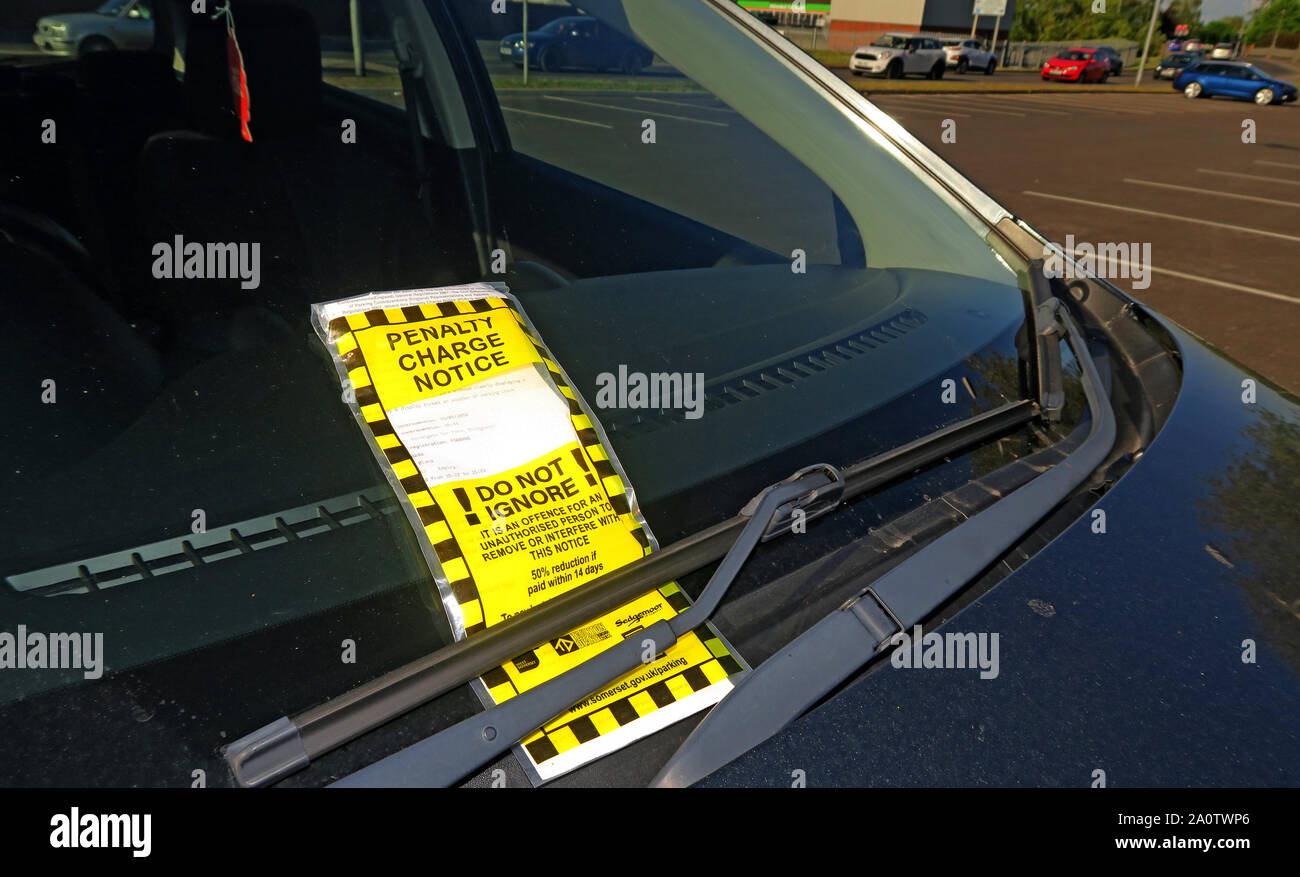 Yellow Parking Penalty Charge Notice on car windscreen under wiper, car park offence, not displaying a valid parking ticket, Sedgemoor, Taunton Stock Photo