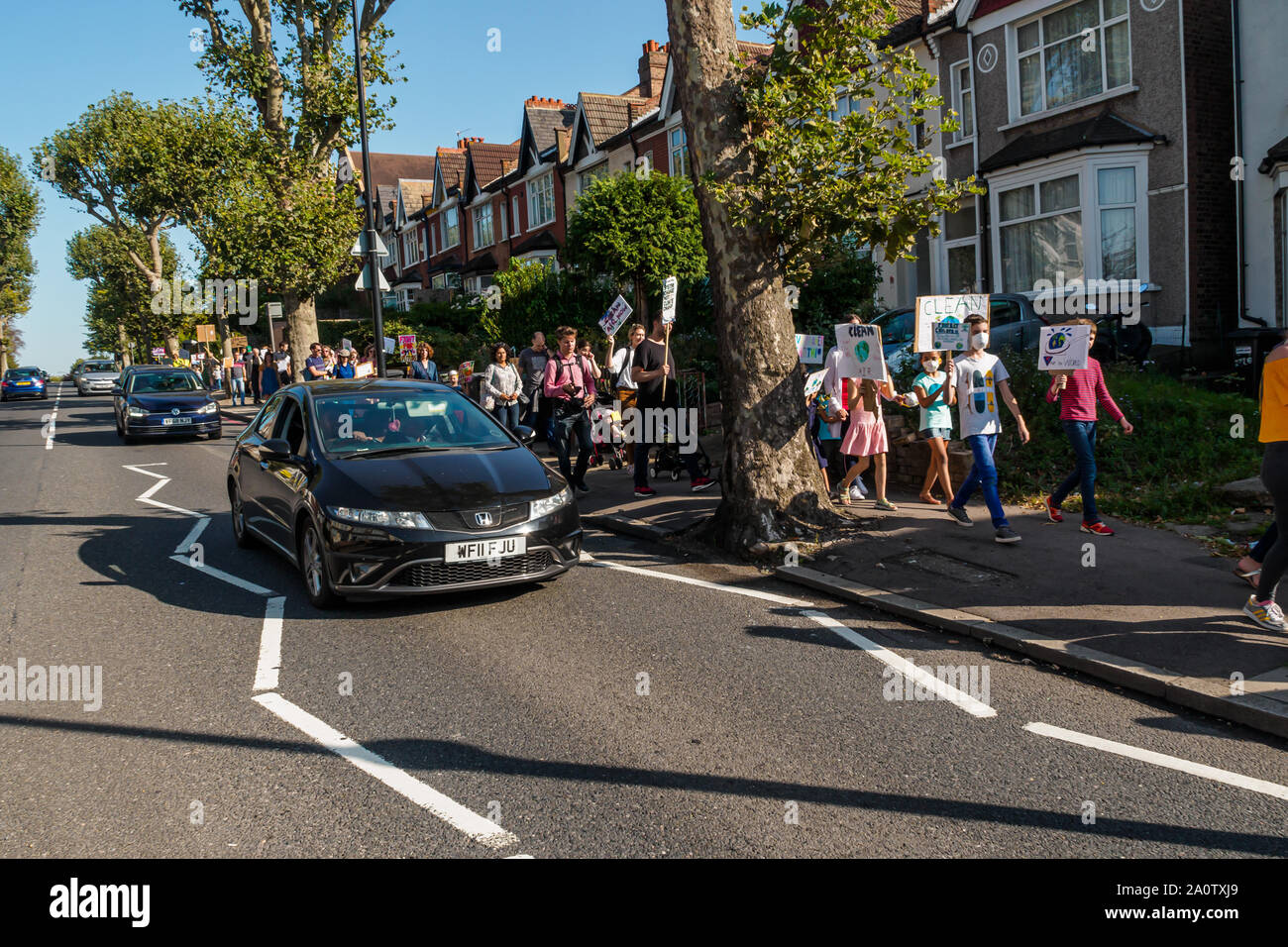 London, UK. 21st September 2019. Families and children march alongside the South Circular Road to a rally in Catford. Clean Air for Catford demand Lewisham Council take bolder and faster action to reduce air pollution, particularly around schools. Continual heavy traffic along the South Circular is largely responsible. Across London two million people, including 400,000 children live in areas with illegal levels of pollution, causing almost 10,000 deaths a year in the city. Peter Marshall/Alamy Live News Stock Photo