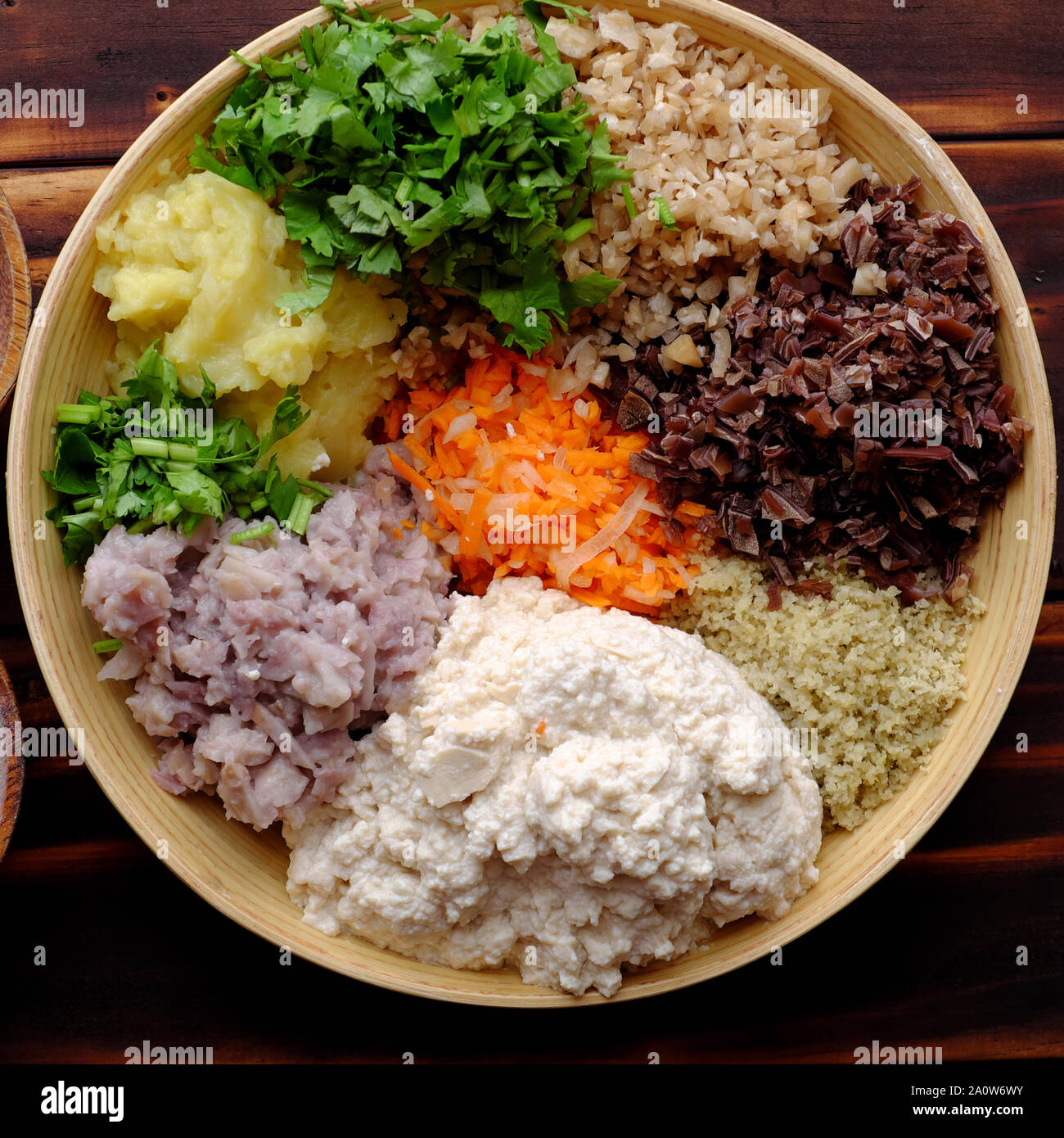 Top view prepare food ingredient for fried vegan tofu pie, raw materials from tofu, mushroom, carrot, green bean, taro, coriander, chopped vegetables Stock Photo