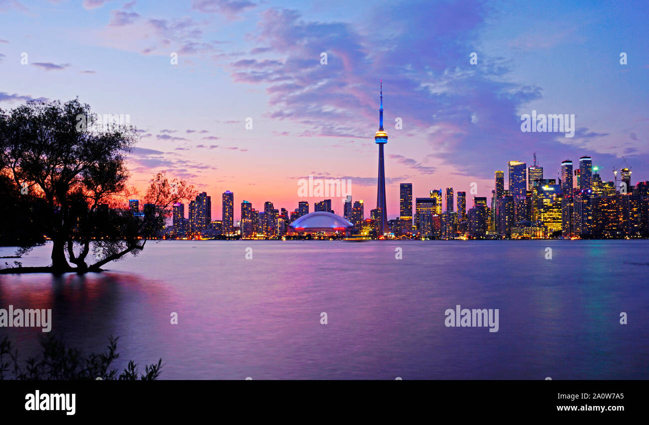 Toronto waterfront syline at dusk, CN Tower in blue and yellow lighting. Stock Photo