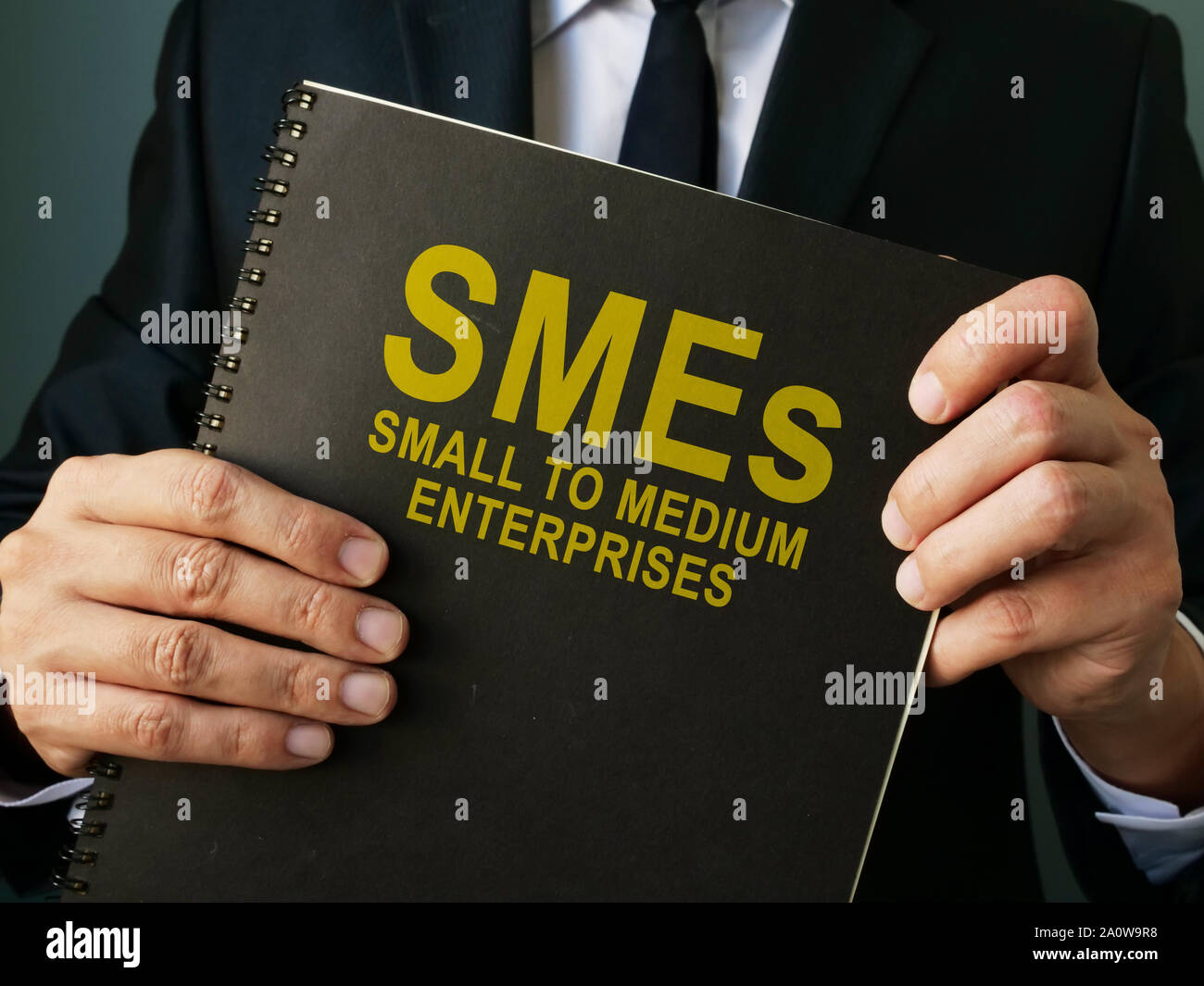 Businessman holds SMEs Small to Medium Enterprises. Stock Photo