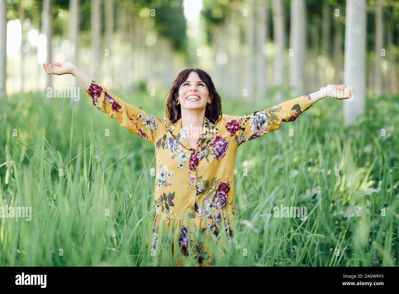 Woman arms raised enjoying the fresh air in green forest Stock Photo ...