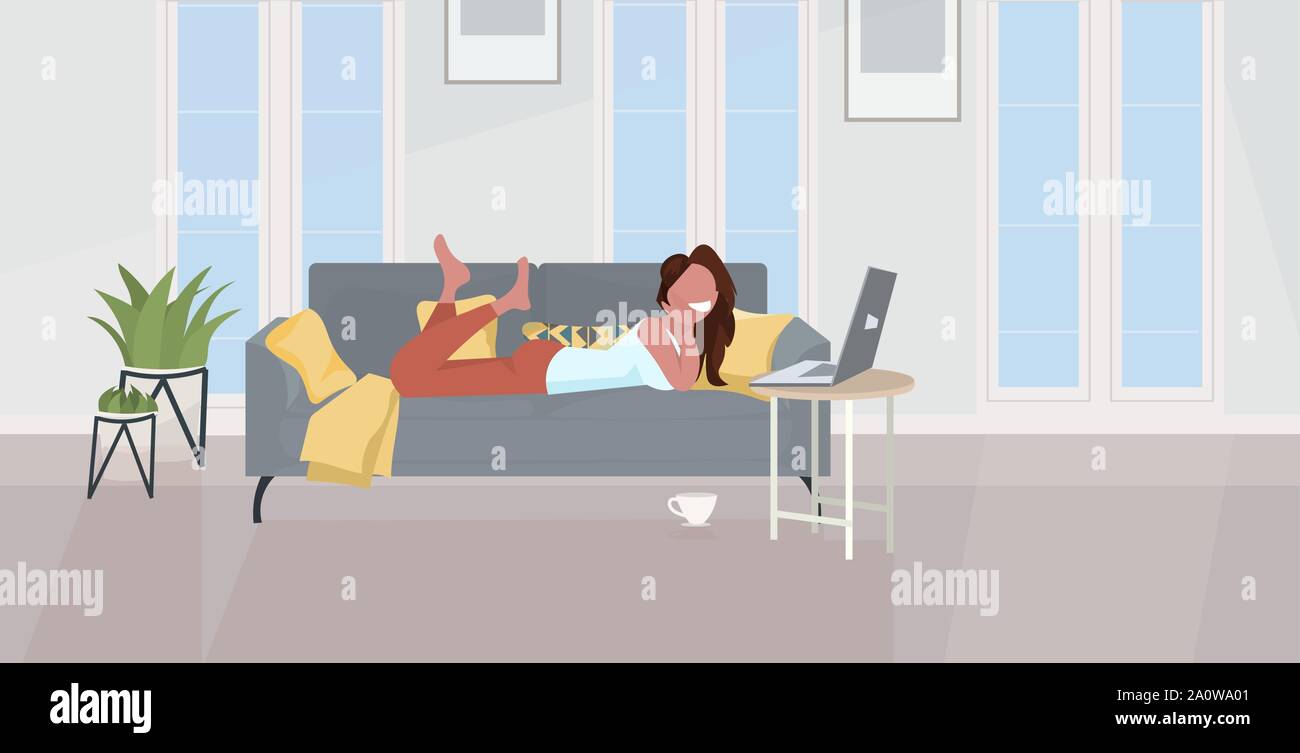 girl lying on sofa using laptop happy woman relaxing at home modern ...