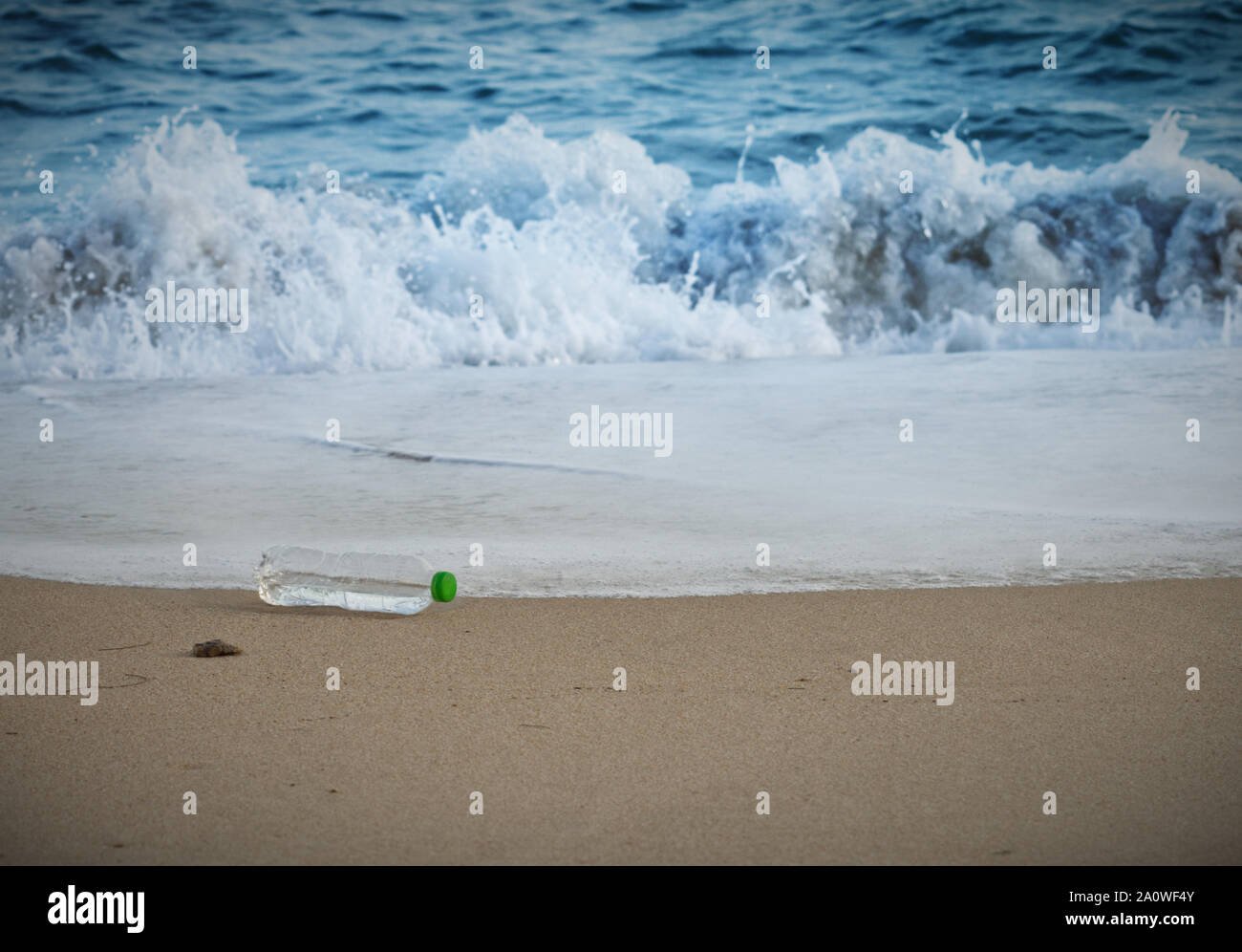 Plastic bottle waste on the beach. Single use plastic botlle being dumped on the beach polluting beach environment and marine life, beautiful blue oce Stock Photo