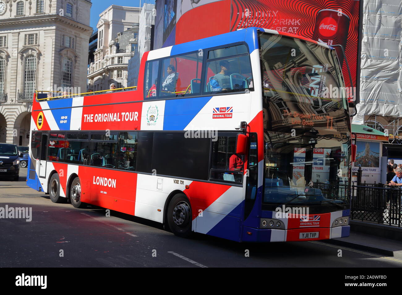 A hop-on  hop-off open top tourist bus at Piccadilly Circus, London, UK Stock Photo