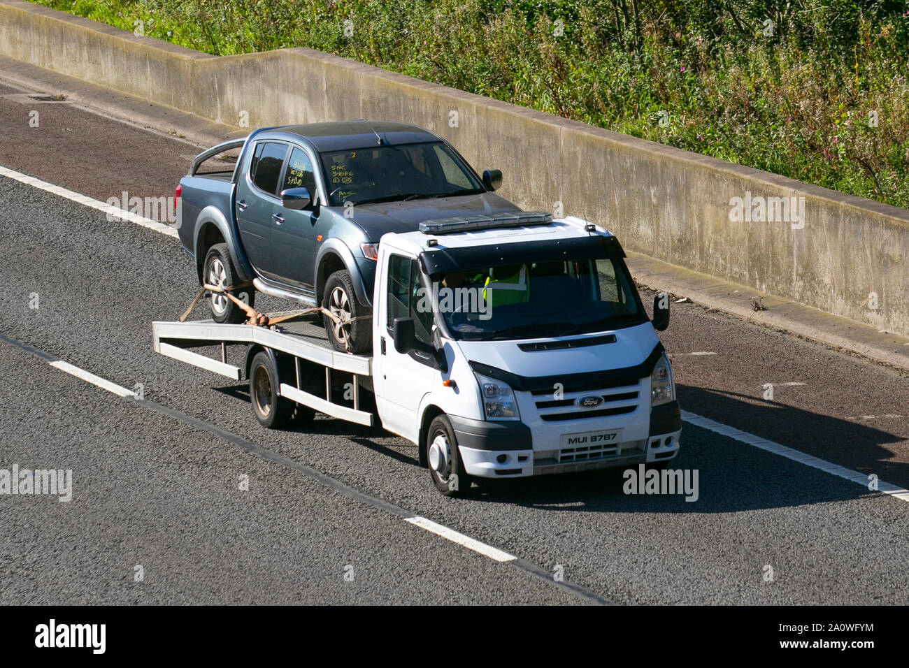 Vehicle roadside Recovery by 2010 Ford Transit 115 T350L RWD; UK Vehicular traffic, transport, modern, saloon cars, south-bound on the 3 lane M6 motorway highway. Stock Photo