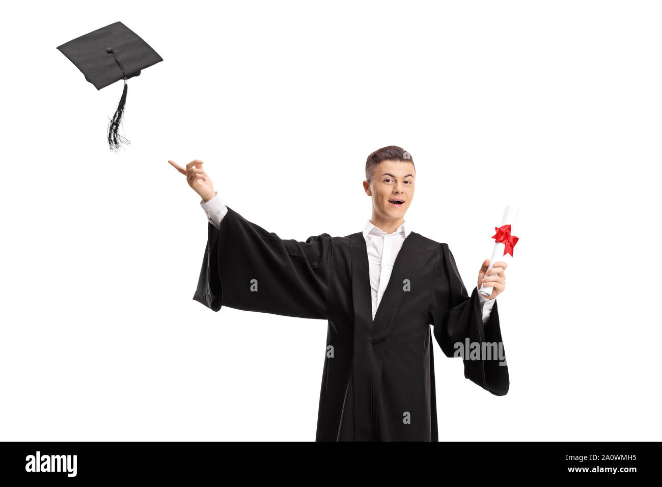 Graduate male student holding a diploma and throwing a graduation hat isolated on white background Stock Photo