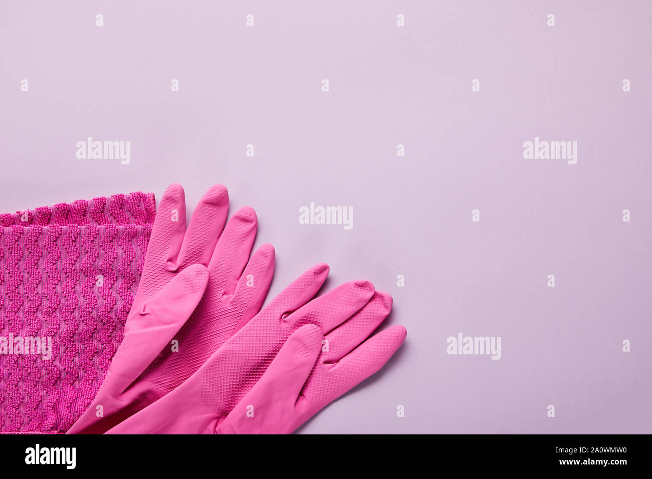 top view of pink rag, rubber gloves on purple background Stock Photo ...