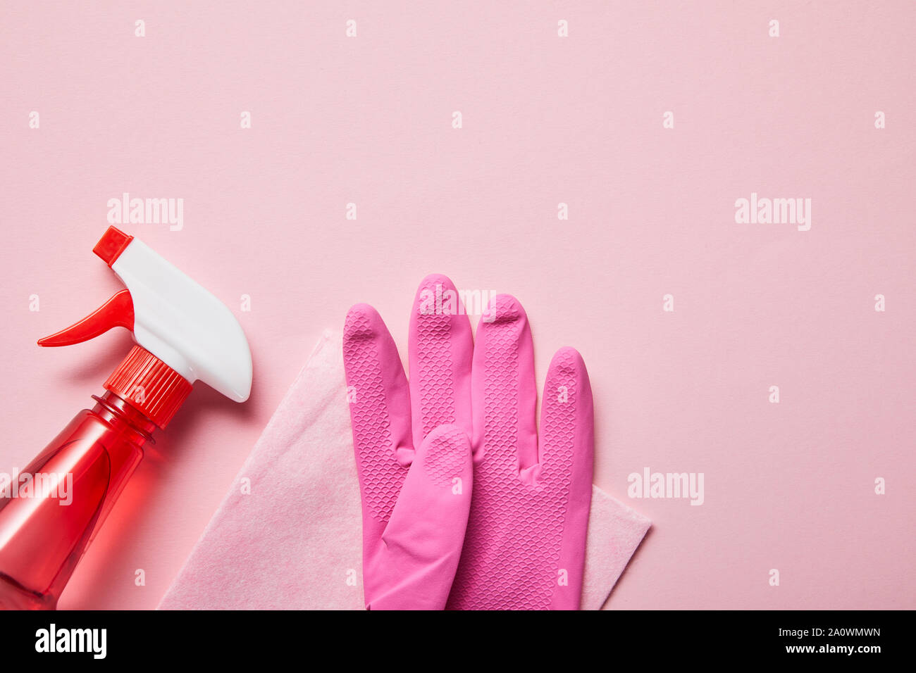 top view of pink rag, rubber glove and bottle with spray on pink ...