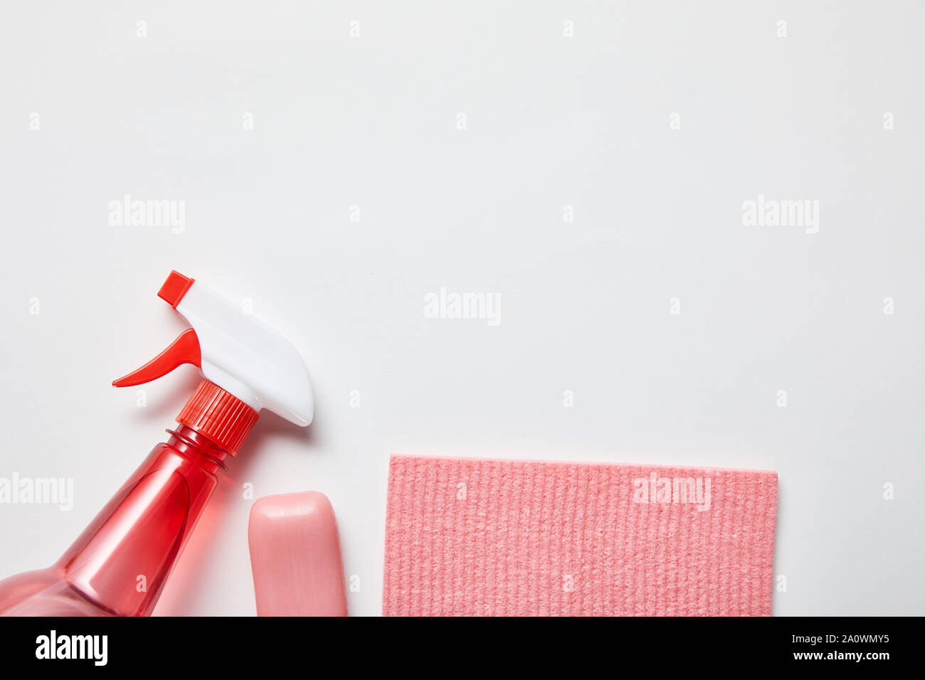 top view of pink rag and soap, bottle with spray on grey background ...