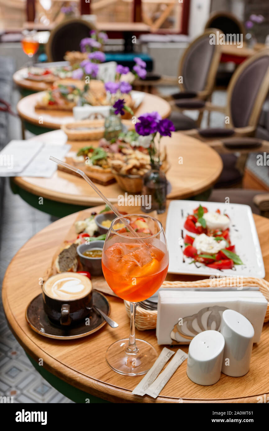Spritz fizz cocktail and various Italian food on restaurant table Stock Photo