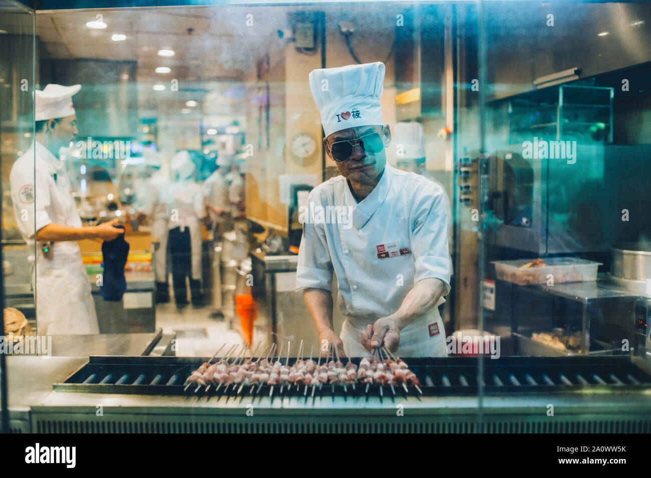Elder staff preparing food in a chinese restant of a shopping mall in Guang zhou. Stock Photo