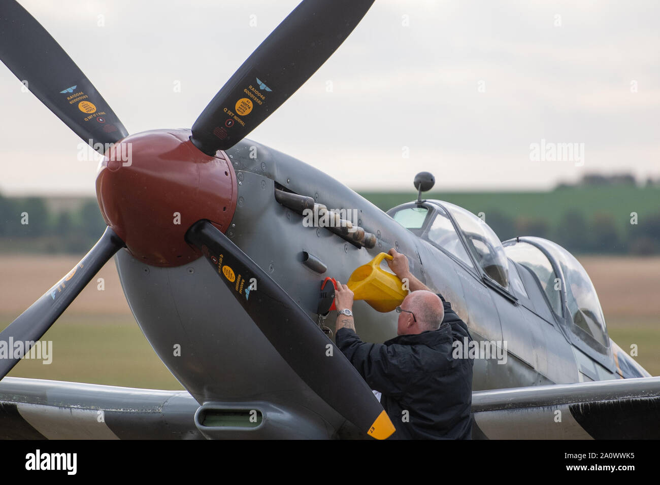 A flight mechanic checks the oil on his Supermarine Spitfire during the Duxford Battle of Britain Air Show at the Imperial War Museum in Duxford, Cambridgeshire. Stock Photo