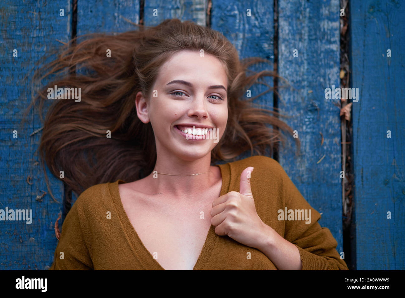 Beautiful Caucasian Young Woman Lying On Her Back On Wooden