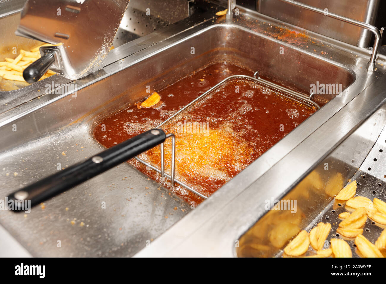 Deep fryer with boiling oil in commercial kitchen, fast food restaurant