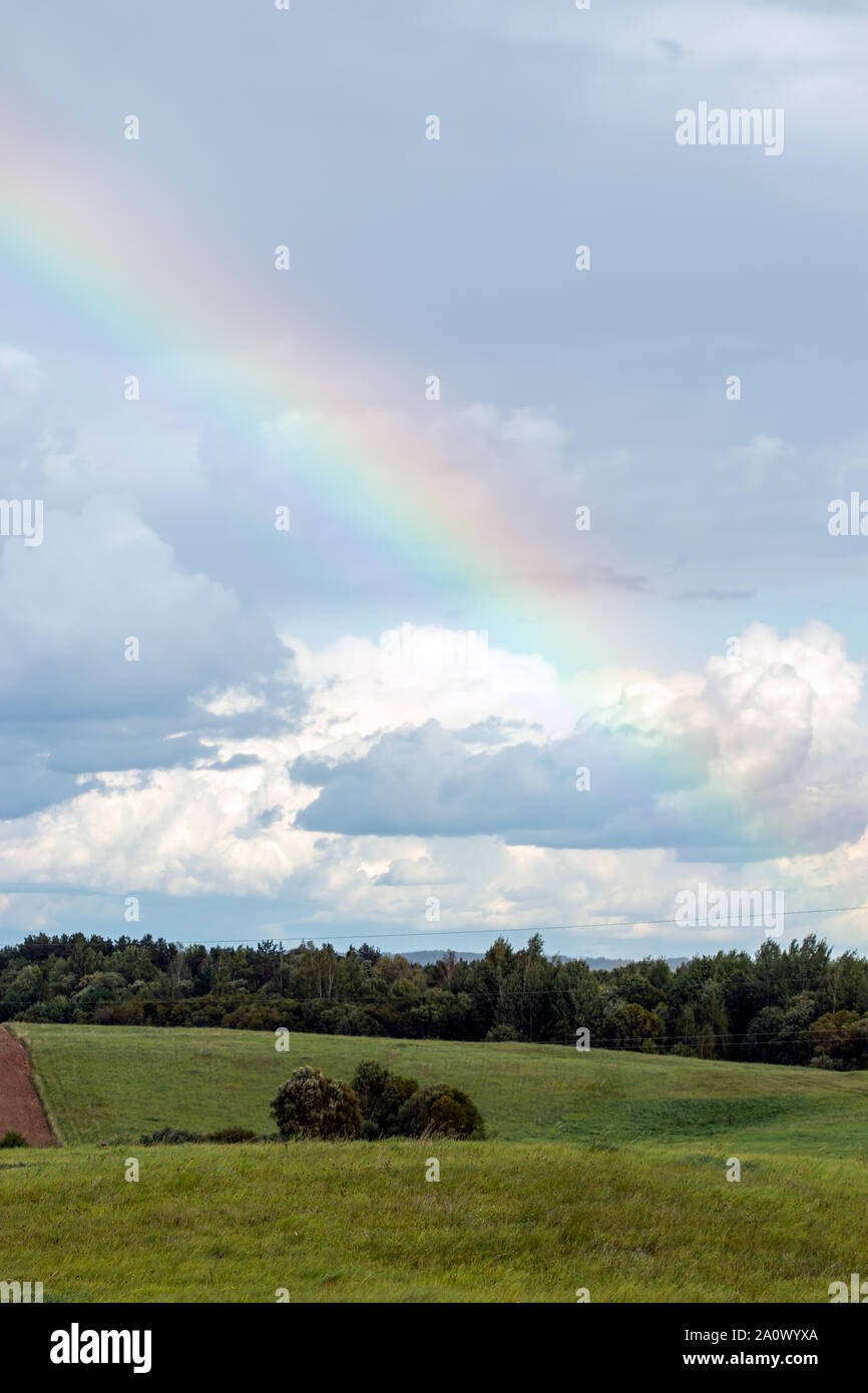 Rainbow over field and forest Stock Photo Alamy