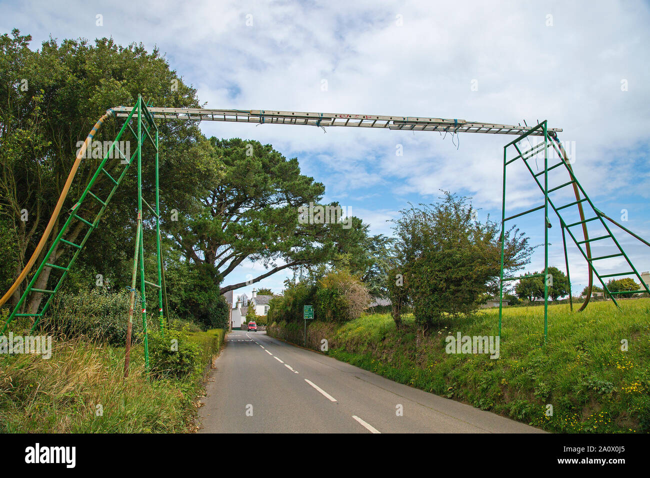 A 'Fred Karno' contraption to support a water pipe over a country road near St Martin, Jersey, Channel Islands Stock Photo