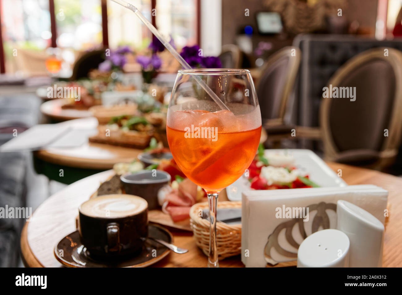 Spritz fizz cocktail and various Italian food on restaurant table Stock Photo