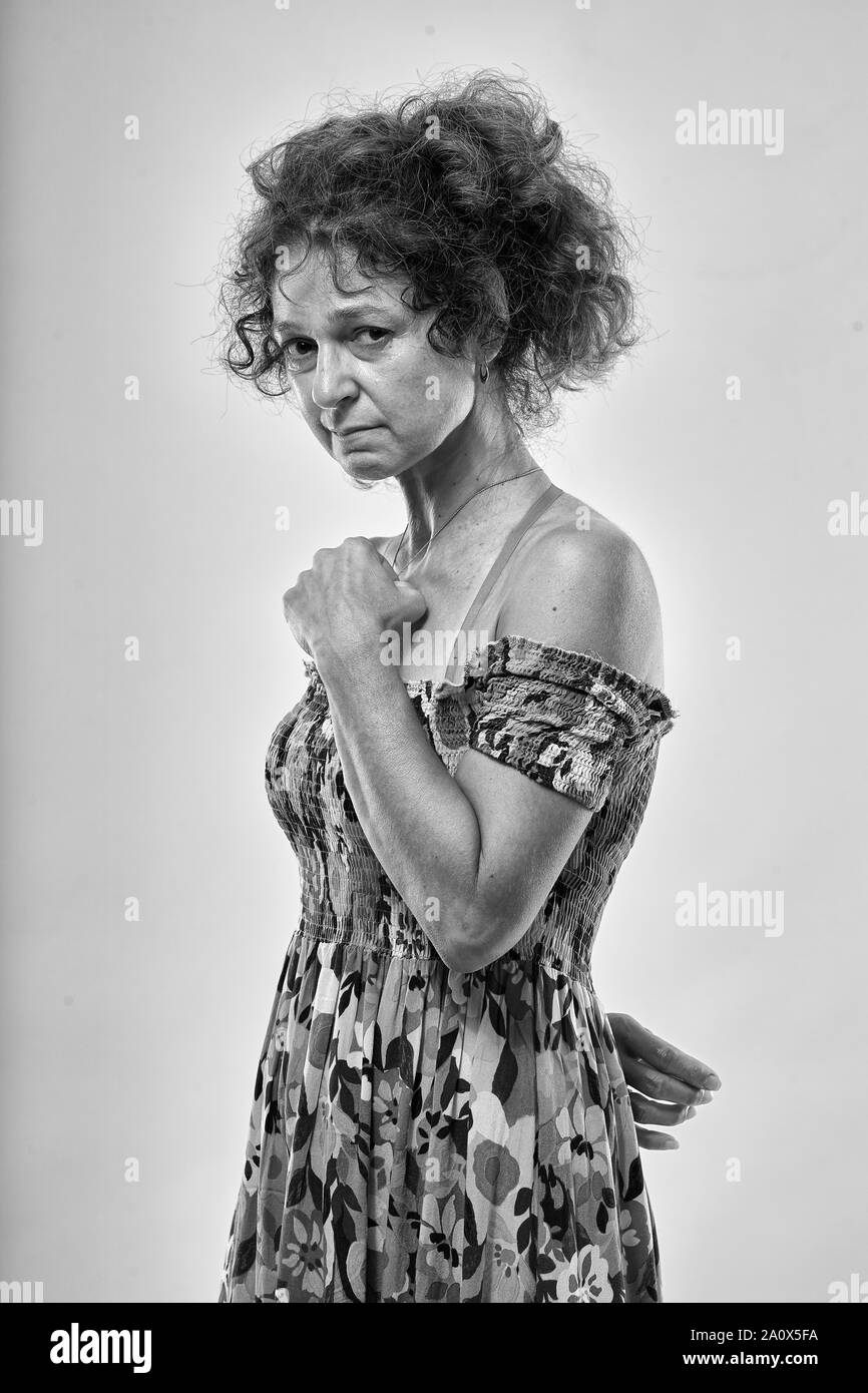Studio portrait of a sad mature woman on gray background Stock Photo ...