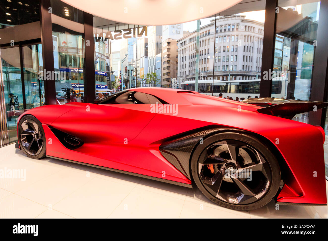 Nissan flagship showroom, Ginza, Tokyo. Display of the concept 2020 Granturismo car, on a revolving platform at glass fronted corner of building. Stock Photo