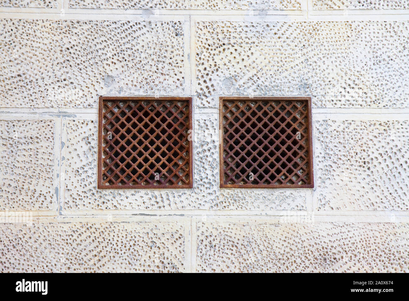 Cast iron ventilation grilles against a plaster wall Stock Photo Alamy