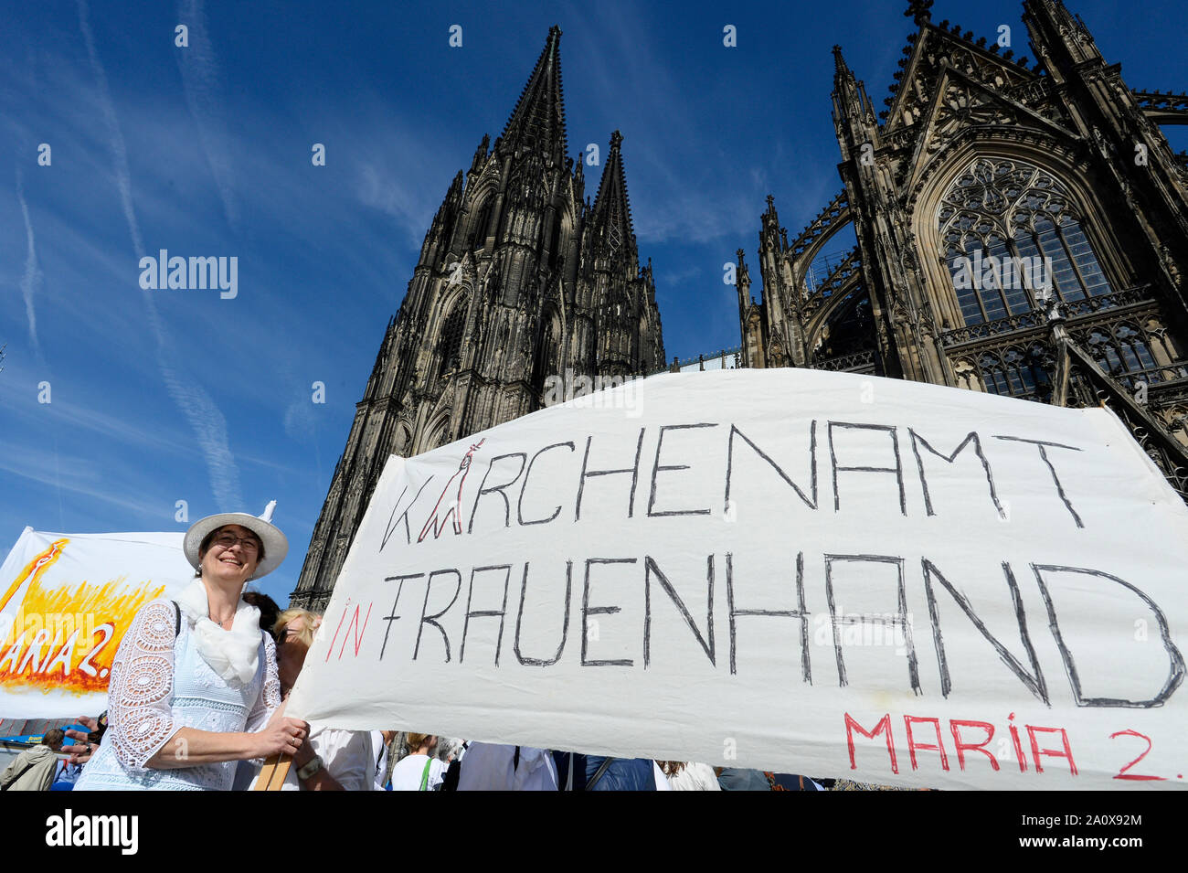 Cologne, Germany. 22nd Sep, 2019. Demonstrators of the 'Maria 2.0' movement stand in front of Cologne Cathedral with a banner with the inscription 'Kirchenamt in Frauenhand - Maria 2.0'. The movement 'Maria 2.0' demonstrated on Sunday with a human chain around the Cologne Cathedral for more equality in the Catholic Church. Credit: Roberto Pfeil/dpa/Alamy Live News Stock Photo