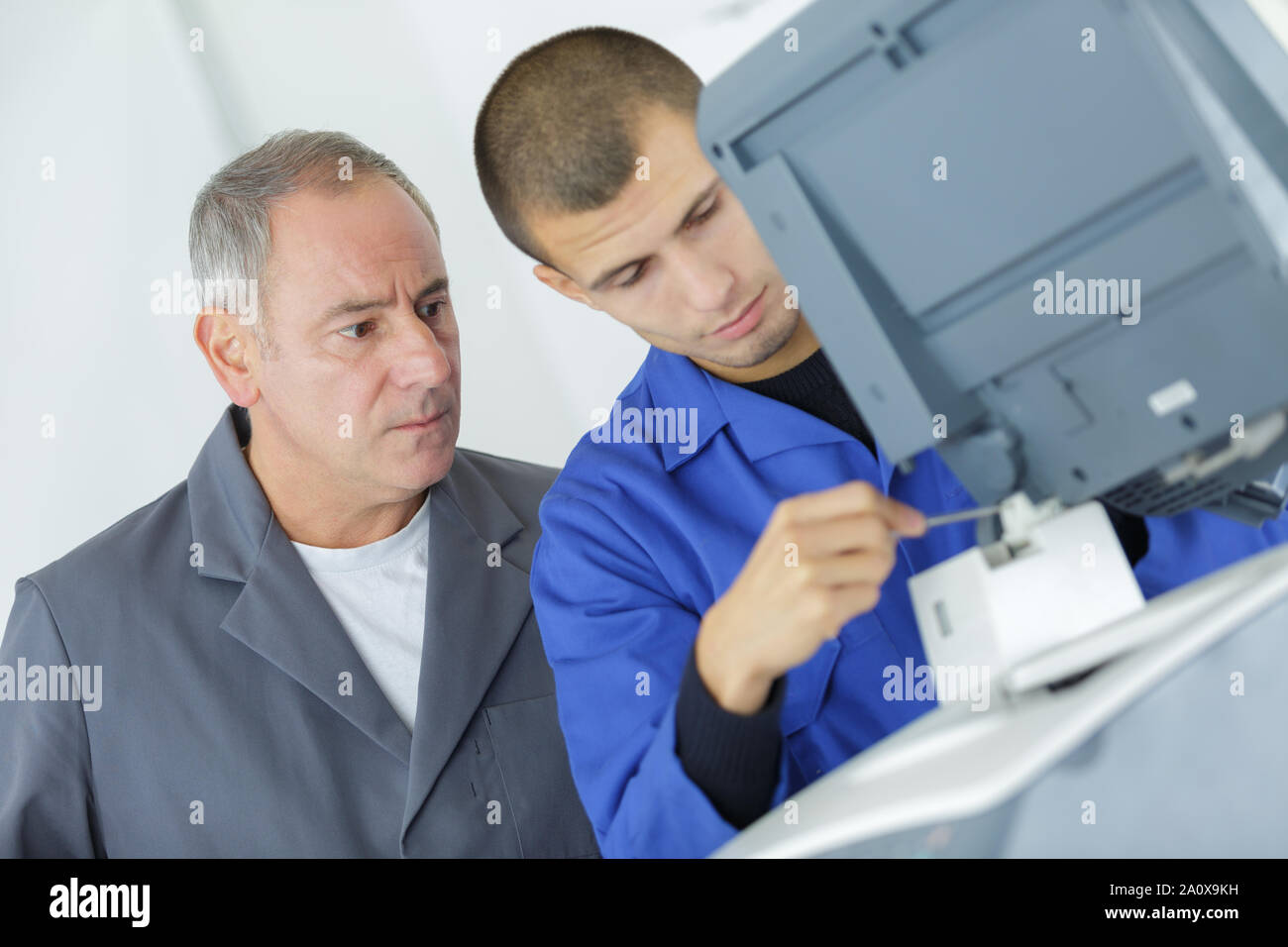 young apprentice fixing cartridge in photocopy machine Stock Photo