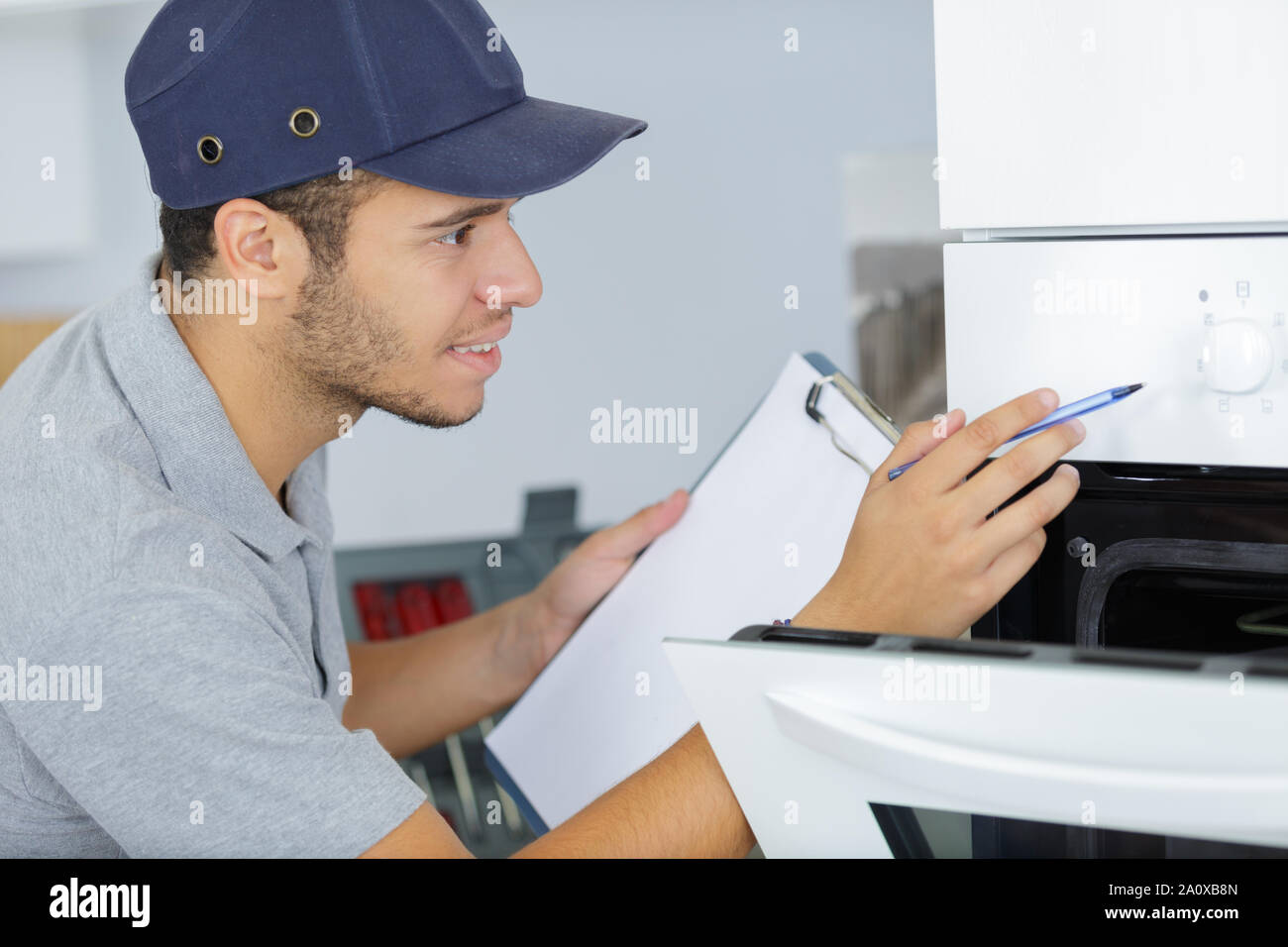 young male technician checking oven Stock Photo