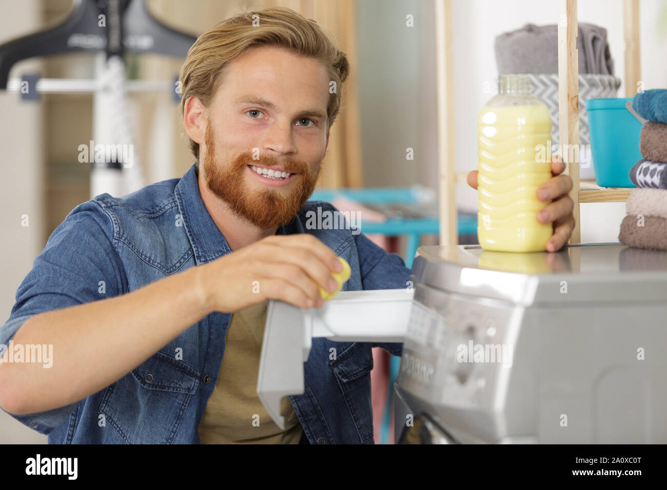 positive young man alone washing cloths Stock Photo