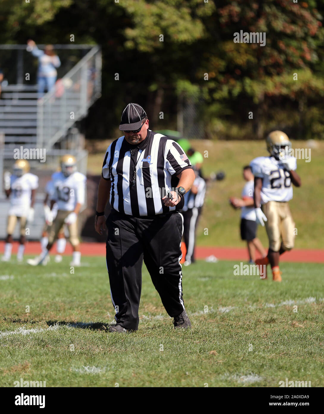 An overweight game official at a high school football game Stock Photo