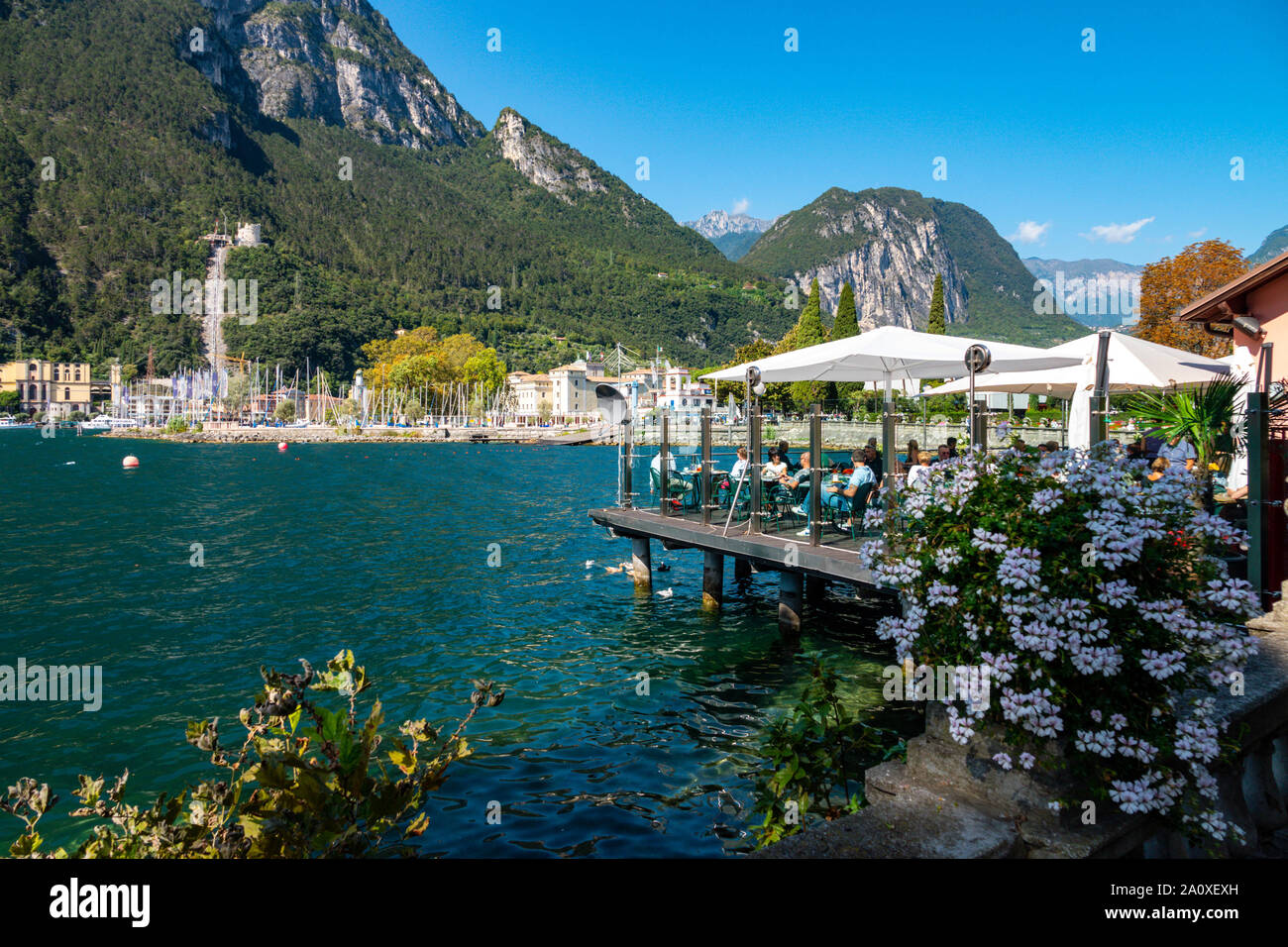People eating at restaurant on platform above lake, Lake Garda, Riva del Garda, Trentino, Alto Adige, Northern Italy Stock Photo