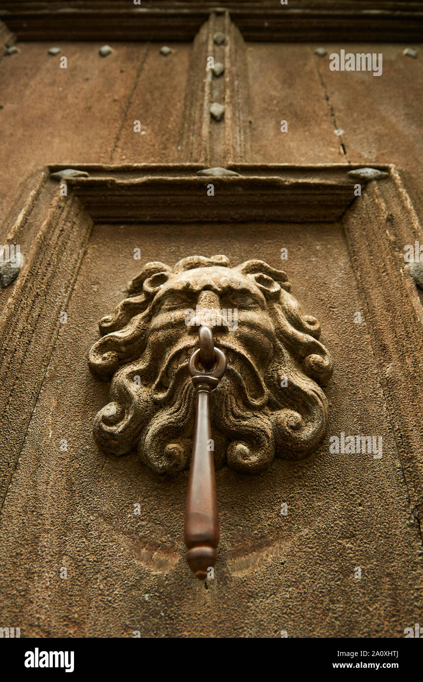 Closeup of a human face door knocker in a vintage wood door of a house in Saint-Lizier (Saint-Girons, Ariège, Occitanie, Pyrenees, France) Stock Photo