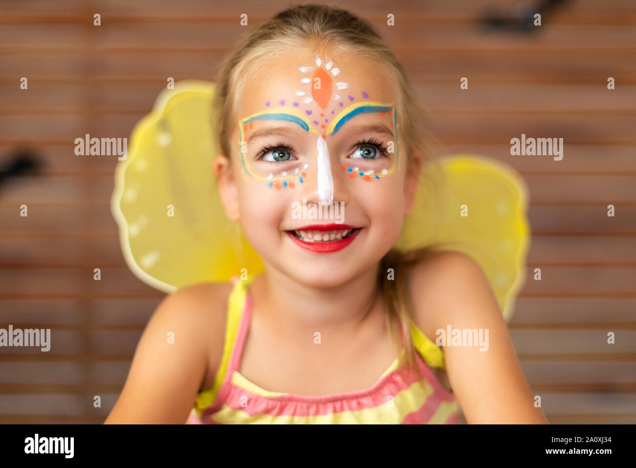 Waist up portrait of cute preschooler with DIY face paint wearing a  butterfly halloween or carnival costume Stock Photo - Alamy