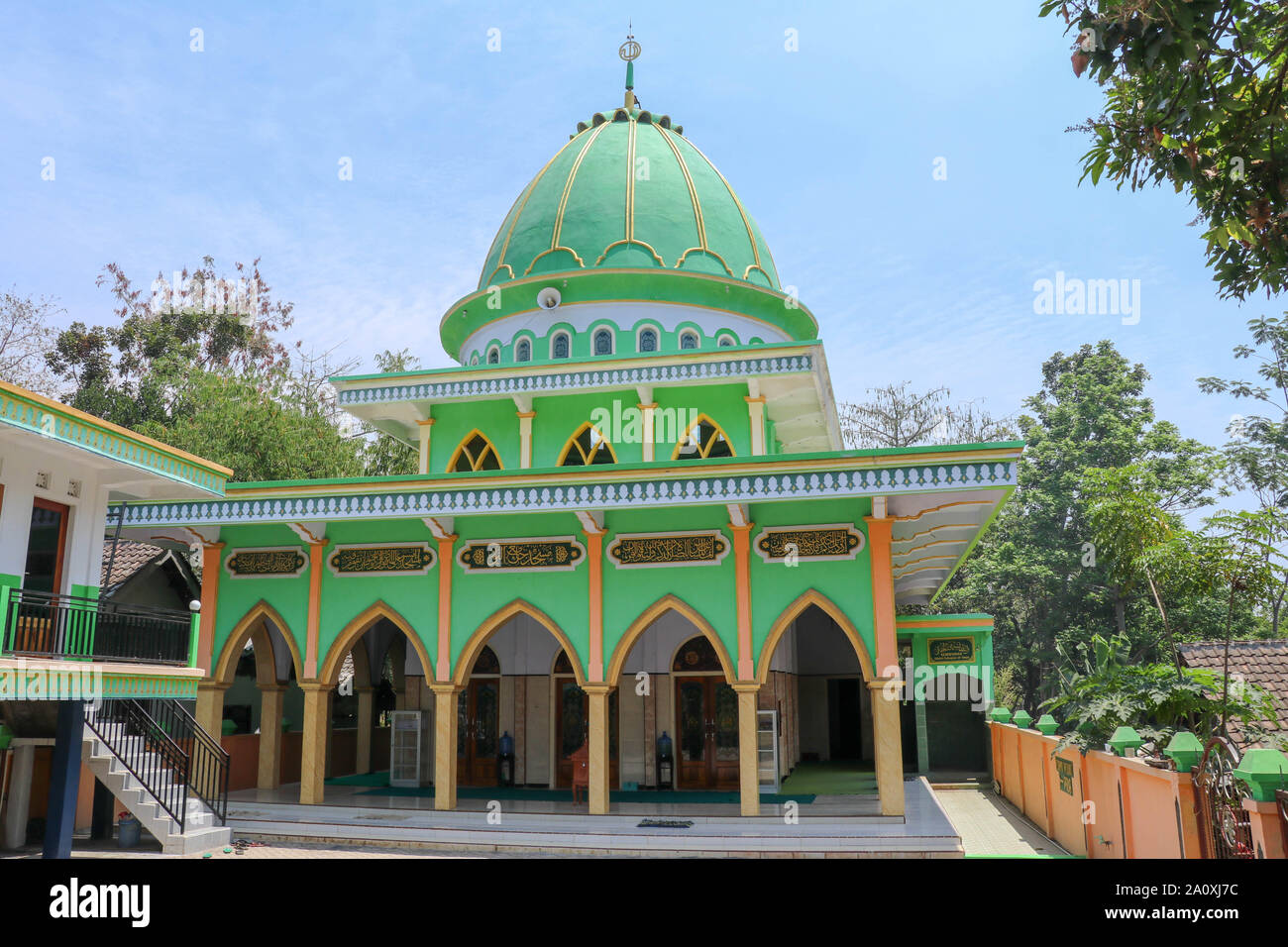 Traditional mosque with lush green facade on Java island in Indonesia. A spiritual place to meet Muslim believers for prayer. Courtyard without people Stock Photo