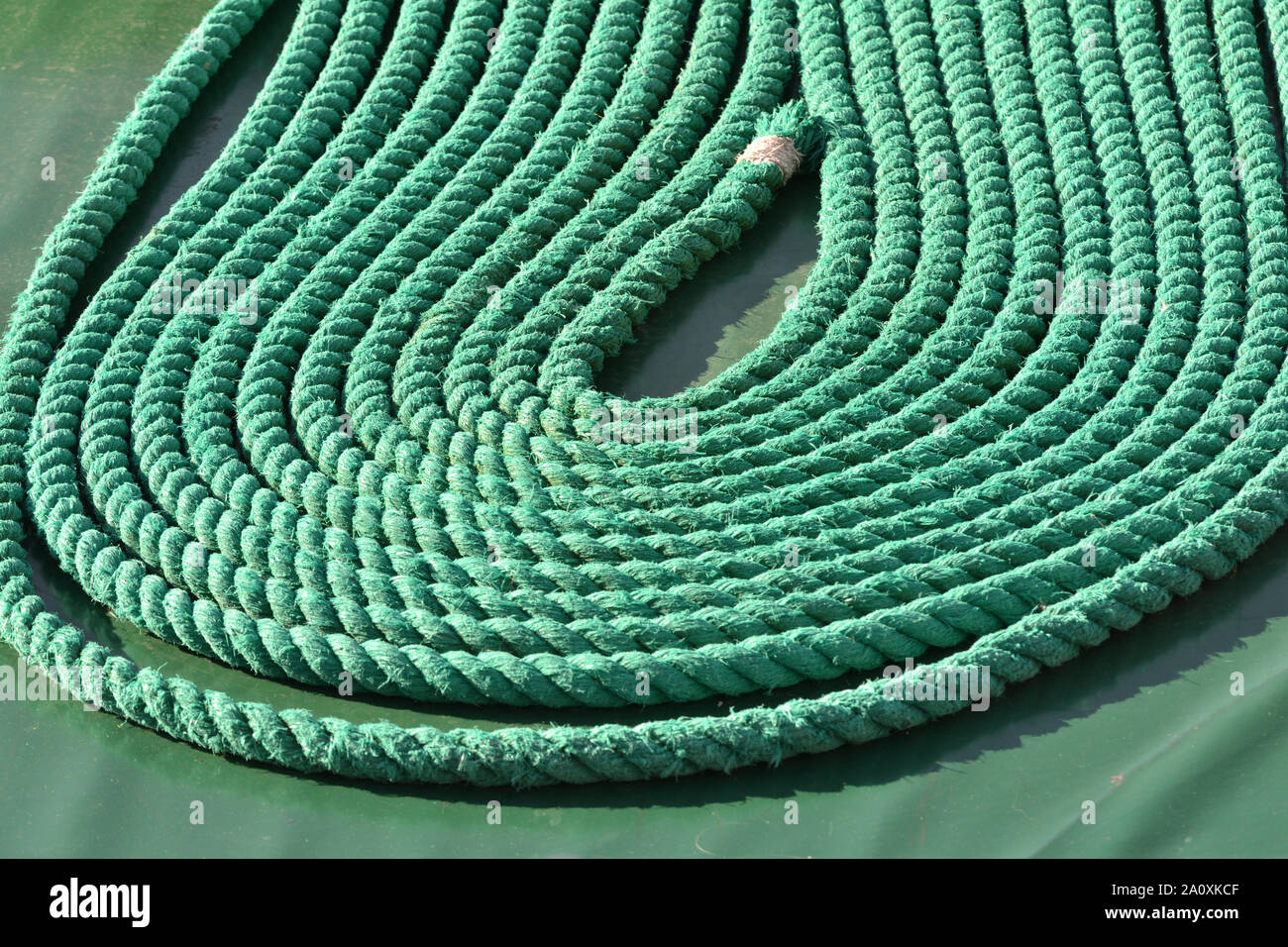 Ship's rope, neatly stowed as per good maritime practice, to avoid tripping Stock Photo