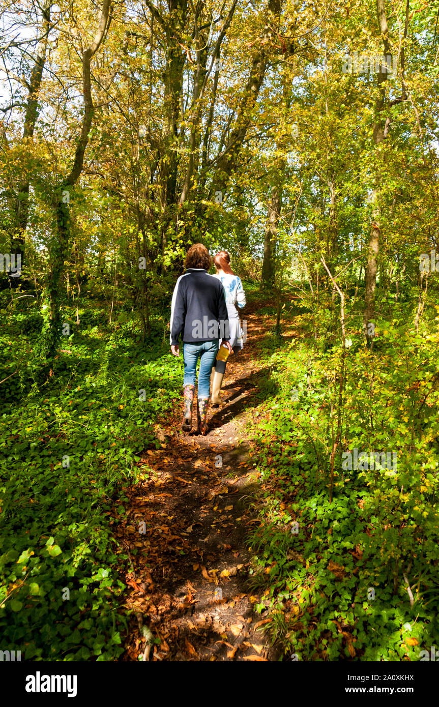 Woman and girl walking in the woods near Wedmore, Somerset, England Stock Photo