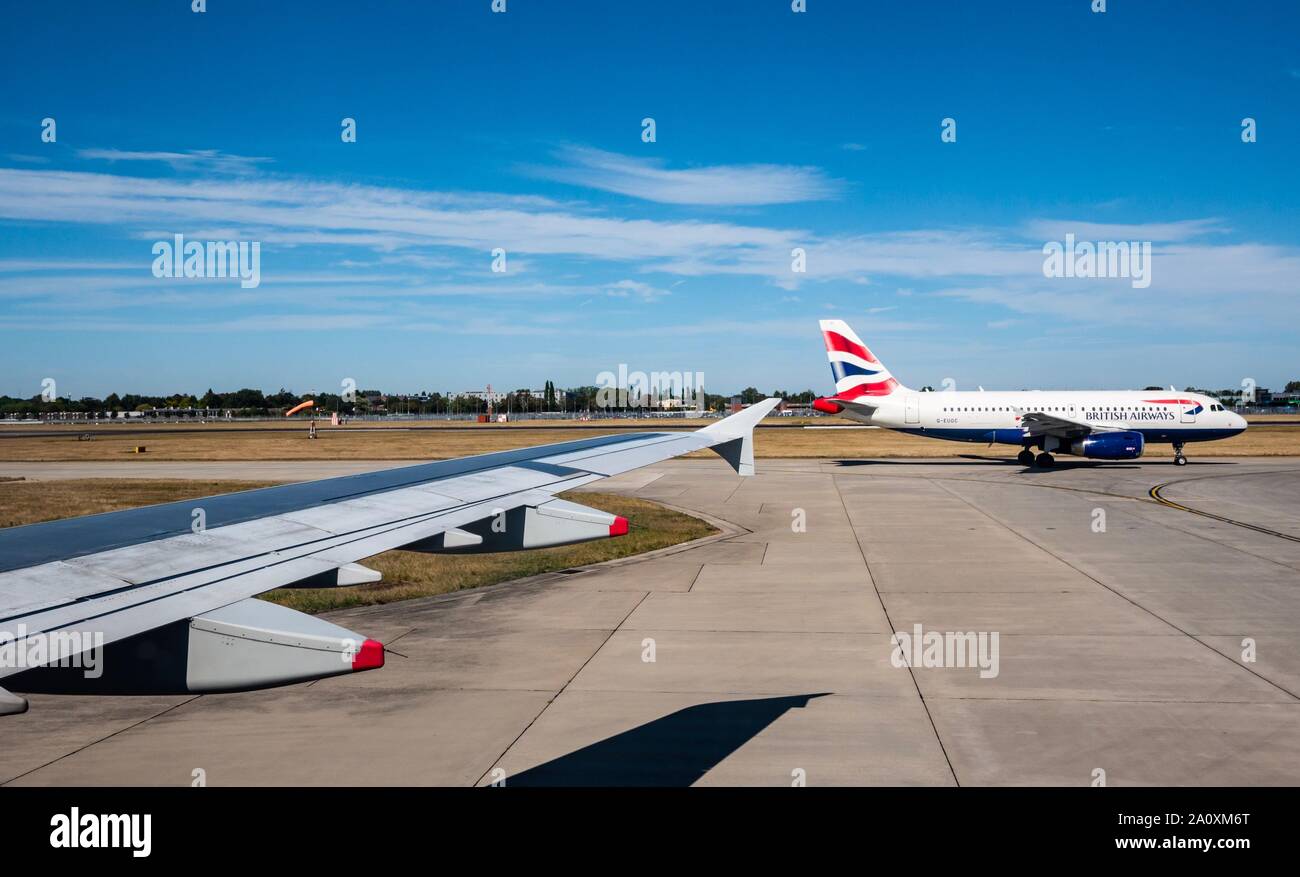 View from plane window of British Airways aeroplane taxiing on runway, Heathrow airport, London, England, UK Stock Photo