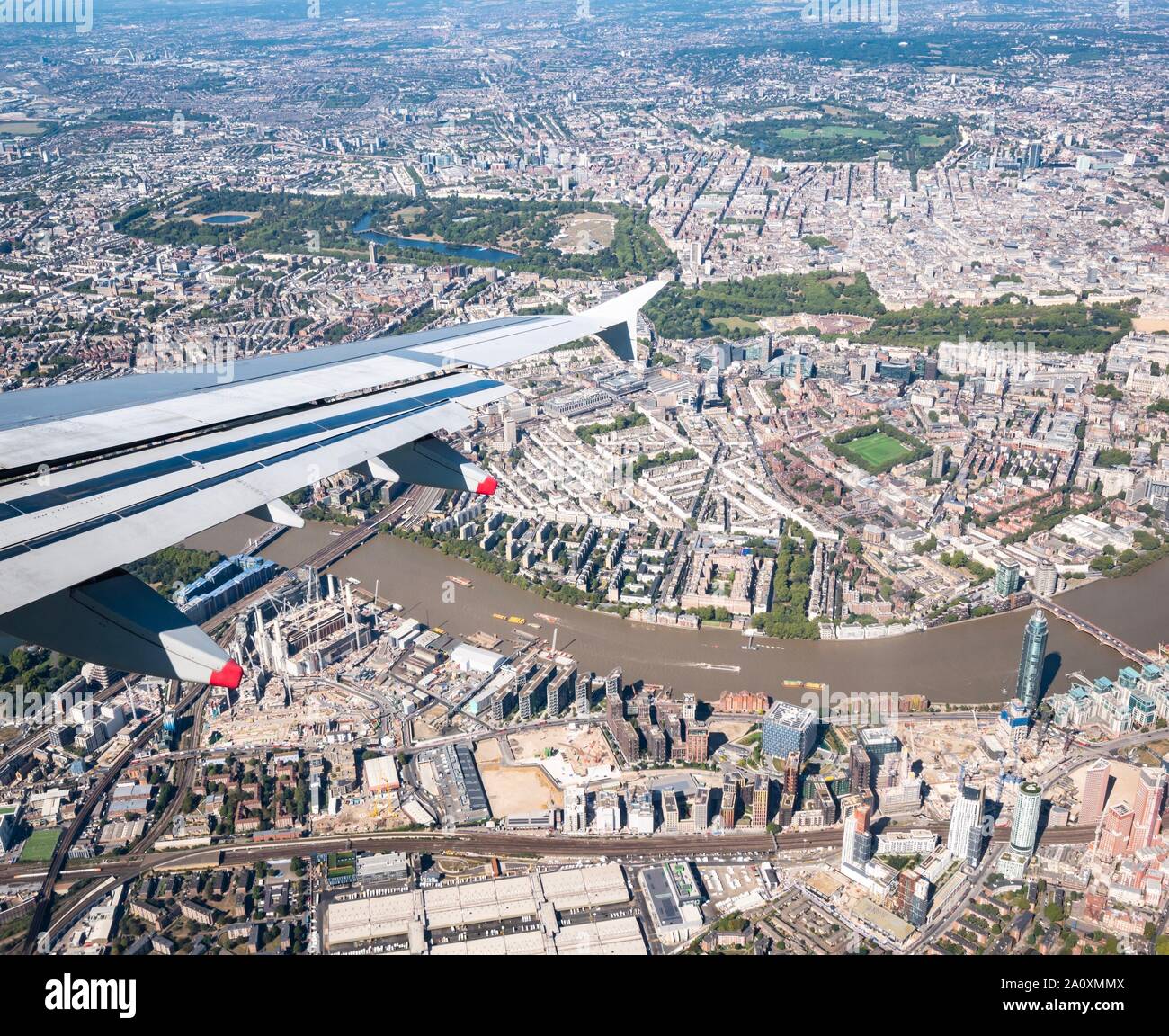 View from plane window with wing over Thames River, Hyde Park, St James Park & Regent's Park & Battersea Power Station, London, England, UK Stock Photo