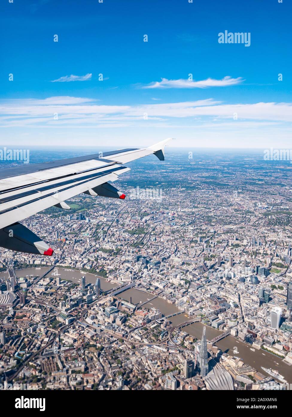 View from plane window with wing over Thames River & The Shard, London, England, UK Stock Photo