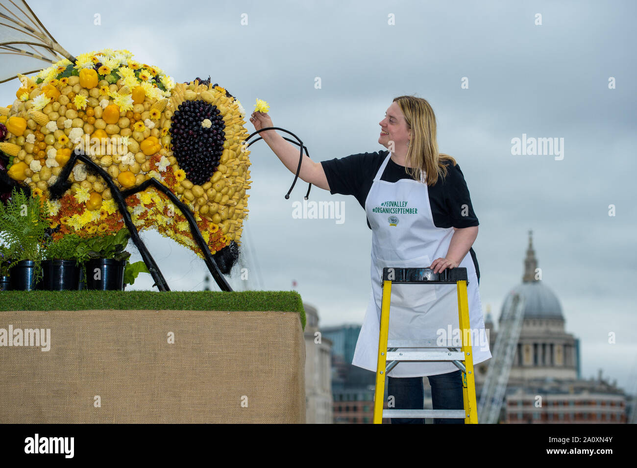 EDITORIAL USE ONLY Food artist Prudence Staite and an edible Bee sculpture, created by Yeo Valley to celebrate Organic September and International Organic Day in Southbank, London. Stock Photo