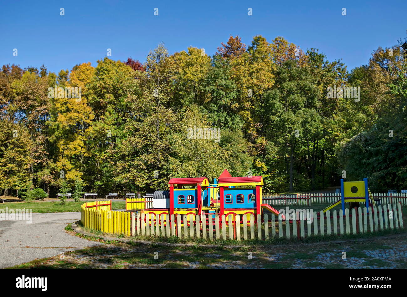 Autumn view of a children's playground in a natural forest with a wooden railway and an outdoor slide, South Park, Sofia, Bulgaria Stock Photo